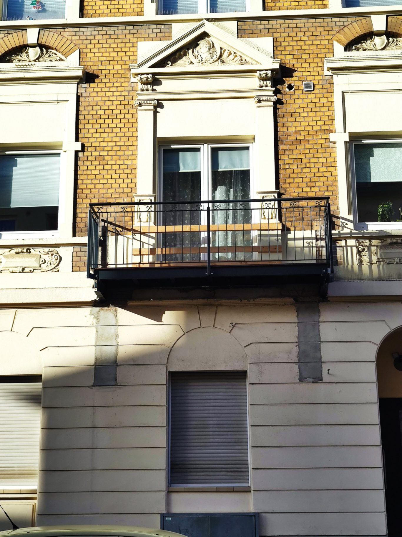 Balkon eines Gebäudes mit verzierten Fenstern und Ziegelmauerwerk.