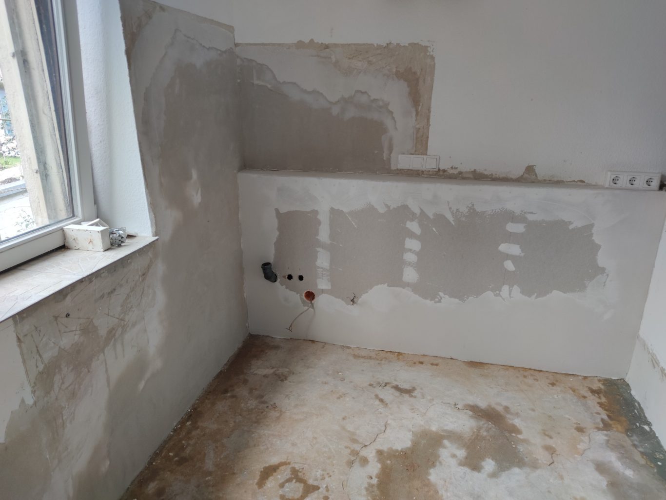 Unfertiger Raum mit freiliegenden Wänden und ungestrichenem Boden.